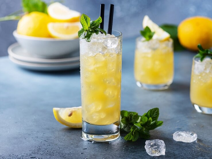 Ein Glas mit Lillet Lemon vor einem grau-blauen Hintergrund.