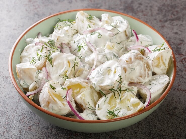 Färskpotatissaladin Schüssel auf dunklem Untergrund.  | © Getty Images/ALLEKO