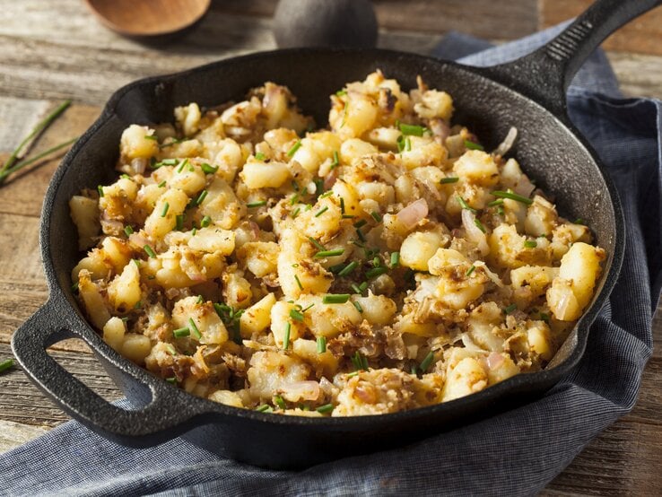 Gebratene Kartoffelstreusel in gusseiserner Pfanne auf hölzernem Untergrund. | © Getty Images/bhofack2