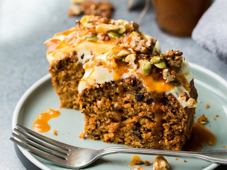 2 Stücke Schoko-Karotten-Kuchen mit einer Gabel auf einem Teller. | © Adobe Stock/ Anna