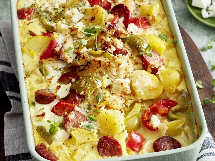 In einer Auflaufform ist eine Portion Ungarischer Sauerkraut-Auflauf serviert. Das Gericht ist mit Oregano garniert.