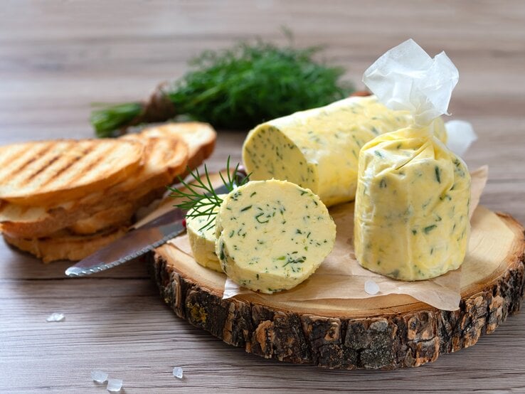 Eine Rolle mit Dill-Zitronenbutter auf einer Baumscheibe.