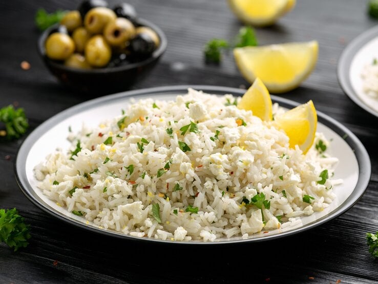 Ein Teller mit griechischem Feta-Reis auf einem schwarzen Tisch.