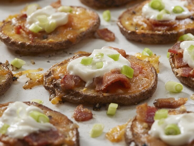 Doppelt gebackenen Kartoffeln mit Schmand und Speck auf weißer Oberfläche. 