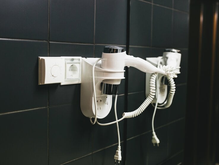 Ein Föhn hängt im Hotelzimmer an der Wand.