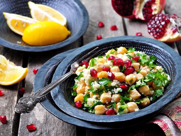 Ein Teller mit Couscous mit Granatapfel und Kichererbsen.