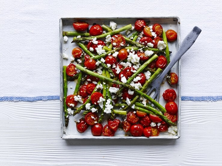 Gebratener Balsamico-Spargel mit Cherrytomaten und Feta auf einem quadratischen Blech. 