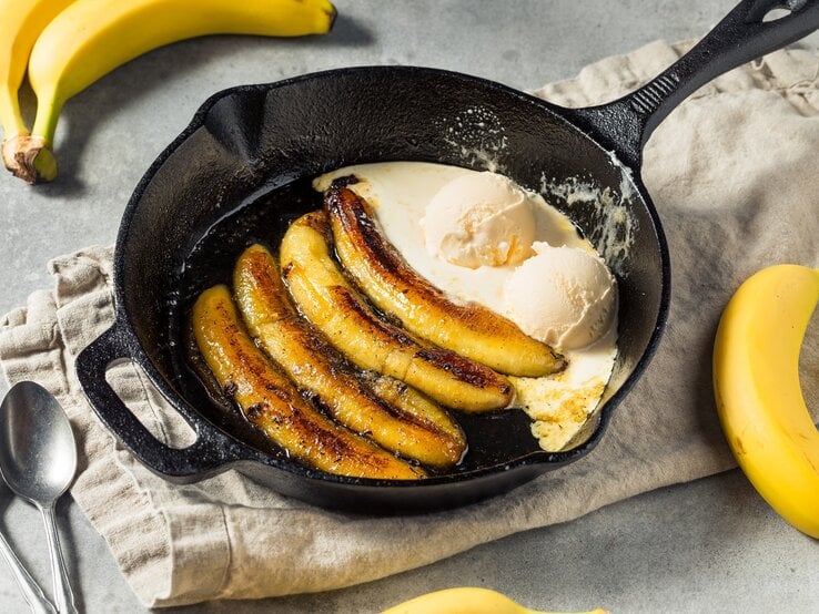 Eine Pfanne mit Rum-Bananen mit Vanilleeis.