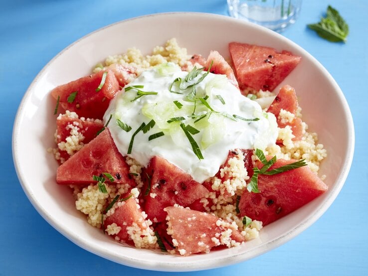 Melonensalat mit Couscous auf Teller serviert.
