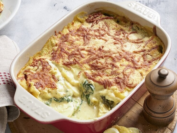 In einer Auflaufform ist ein Eierauflauf mit Senfcreme angerichtet. Er ist mit Käse überstreut. 