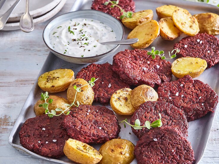 Rote-Bete-Frikadellen mit Kartoffeln auf Tisch serviert.