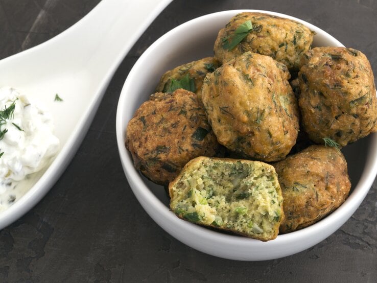 Kartoffel-Erbsen-Frikadellen in weißer Schale mit Tatarsoße daneben. 