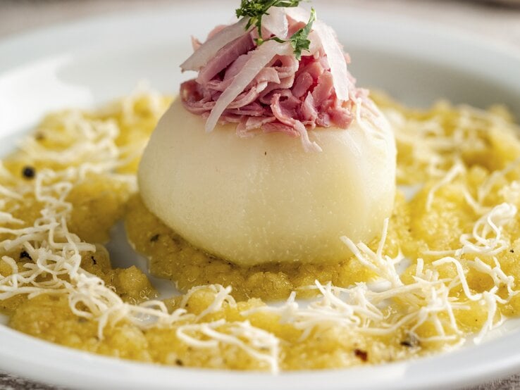 Saftiger gebackener Kohlrabi gefüllt mit Schinken auf einer Kohlsuppe mit Äpfeln, gewürzt mit Currypulver und geriebenem Rettich