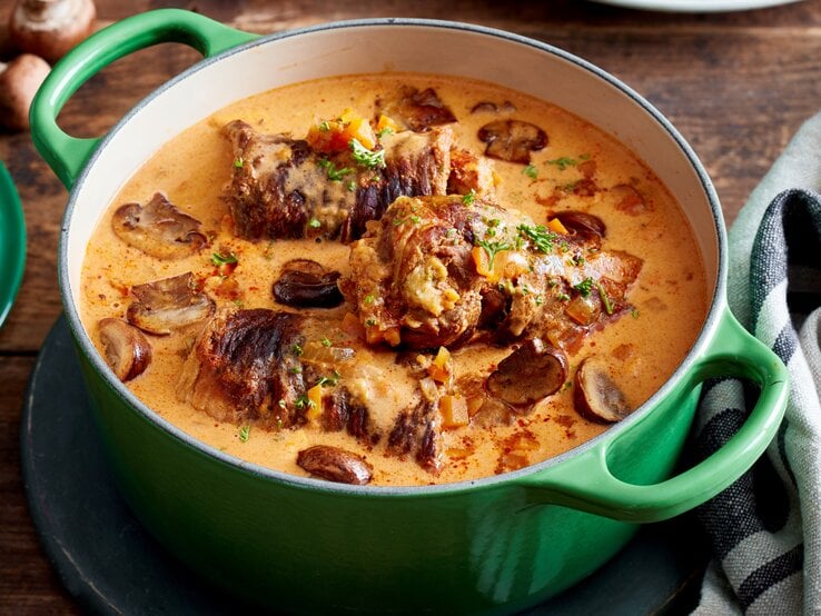 Rindsrouladen mit Knödelmix / gusseiserner Topf / Draufsicht schräg / Untergrund aus Holz