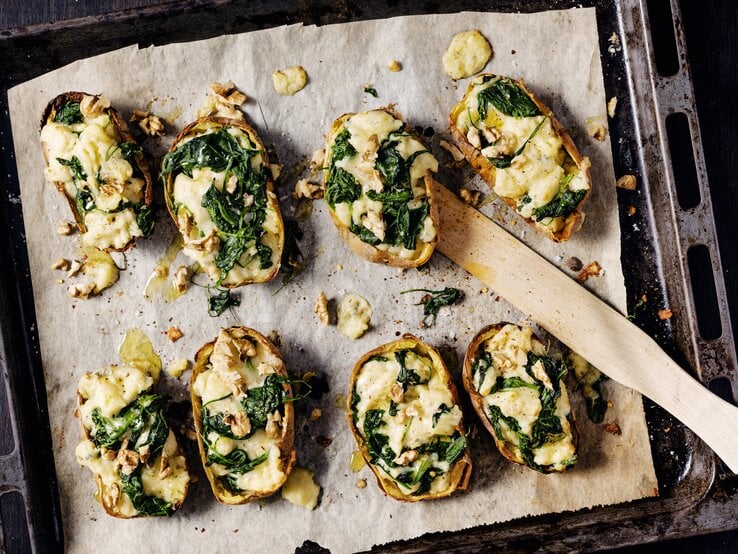 Gefüllte Kartoffelschalen mit Spinat und Gorgonzola auf einem Backblech. 