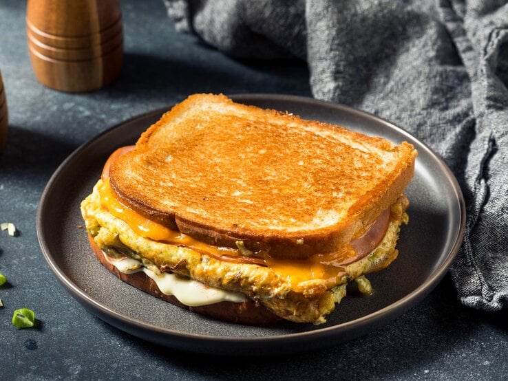 Ein zusammengeklapptes Toast auf einem grauen Teller und grauem Untergrund.