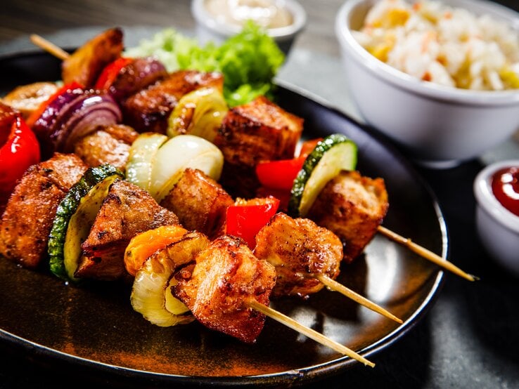 Saftig-zarte Schweinefiletspieße mit Gemüse frisch gegrillt auf dem Teller.