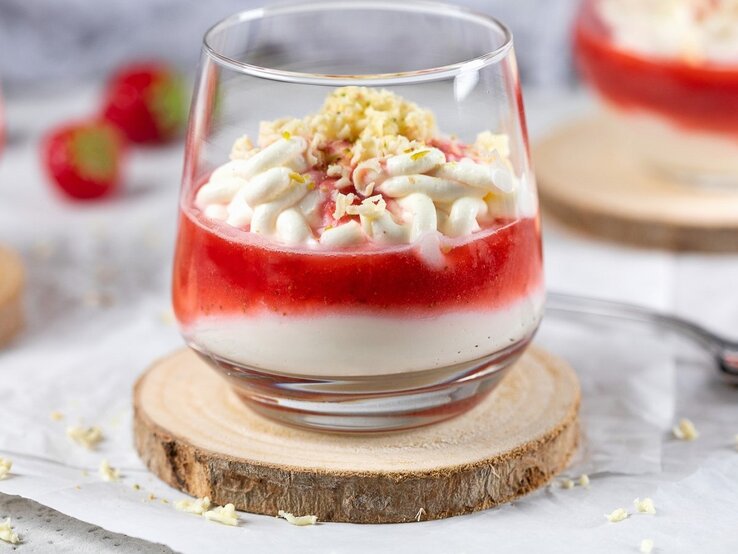 In einem Glas ist ein Spaghetti-Eis mit Mascarpone und Erdbeersauce angerichtet. Es ist mit weißer Schokolade bestreut.  | © StockFood / Diana, Ruchser