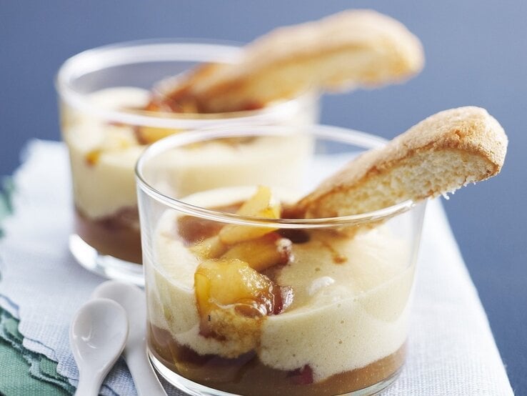 In zwei Gläsern ist ein Dessert nach Tiramisu-Art mit Apfel und Apfelwein angerichtet. 