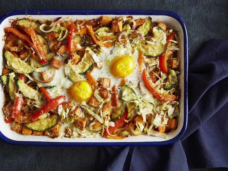 Draufsicht: Eine weiße Form in dem ein Gemüseauflauf mit Spiegeleiern ist. | © StockFood / Gräfe & Unzer Verlag / Walsh, Nicky