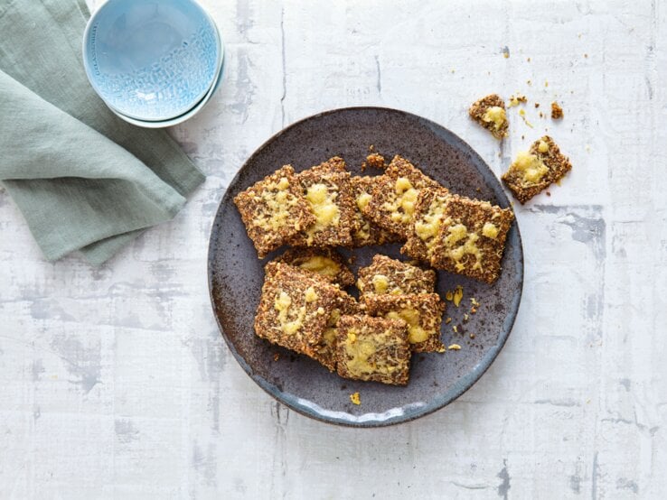 Ein schwarzer Teller mit dem Knäckebrot direkt von oben fotografiert.