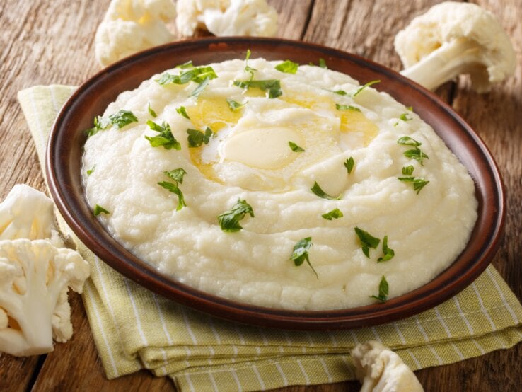 braune Schale mit Blumenkohlpüree auf Holztisch. 