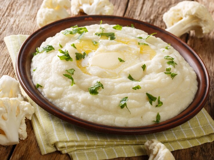 braune Schale mit Blumenkohlpüree auf Holztisch.  | © iStock/ALLEKO