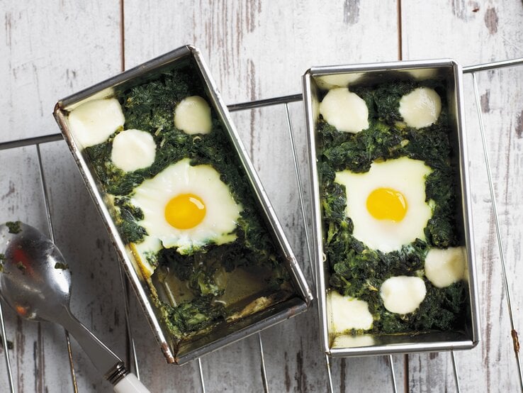 Draufsicht: Eine Form mit gegartem Spinat und gegarten Eieren. | © StockFood