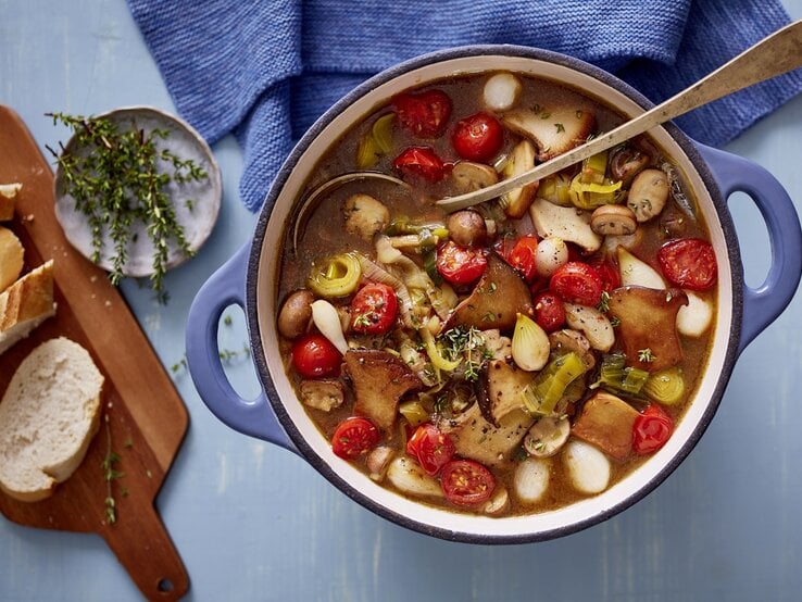 Pilzgulasch in rundem Topf, darin eine Suppenkelle. 