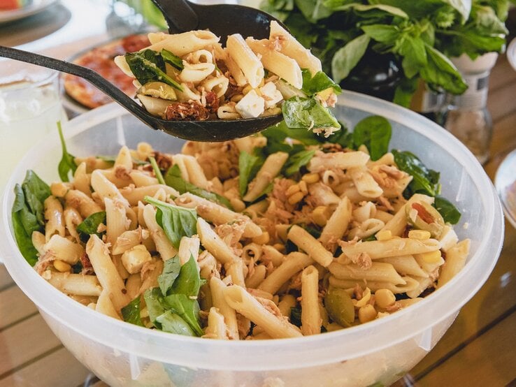 Schüssel mit Nudelsalat auf einem Holztisch. | © iStock/SolStock