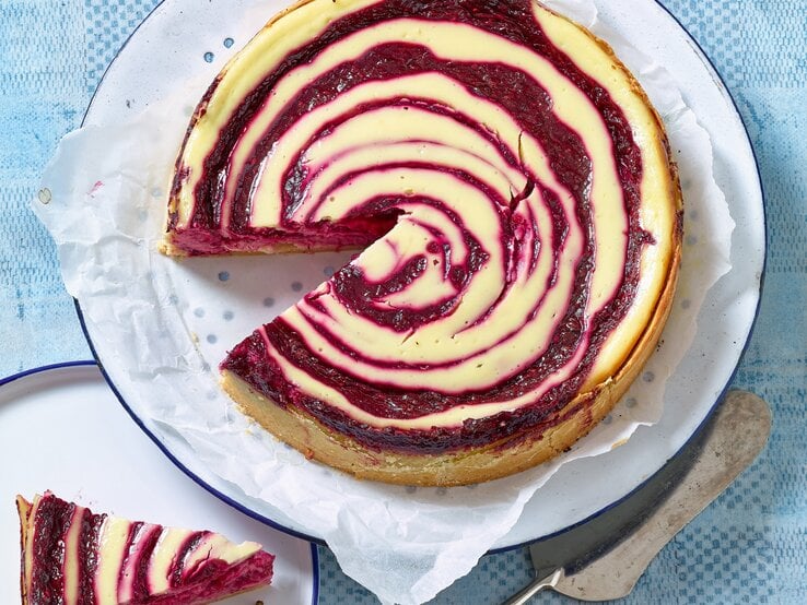 Käsekuchen mit Rote-Grütze-Quirl von oben fotografiert. 
