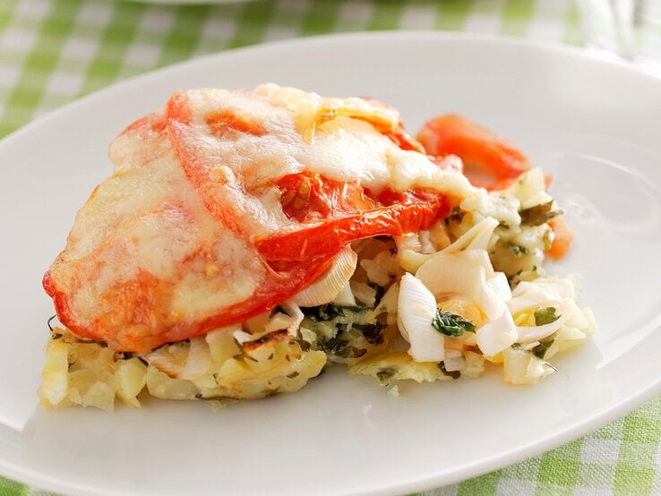 Eierlasagne auf einem weißen Teller. Das Ganze auf einer weiß-grün karierten Tischdecke