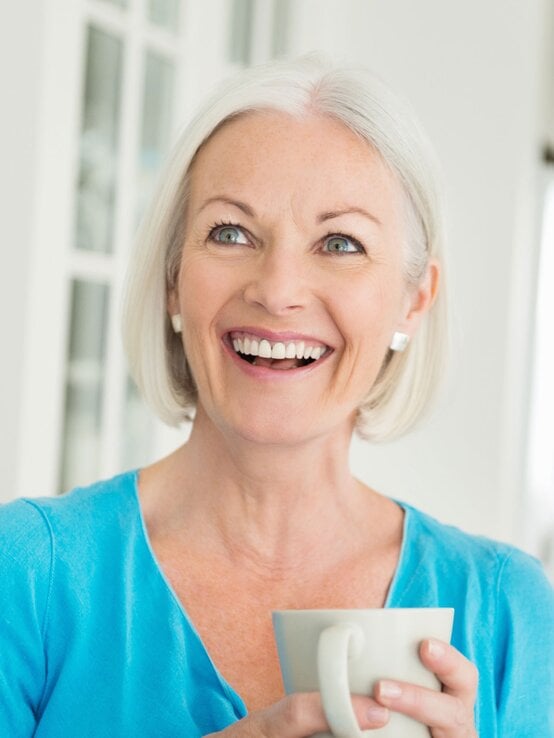 Grauhaarige Frau mit kurzer Bob-Frisur, die eine Kaffeetasse in der Hand hält.  | © iStock/JohnnyGreig 