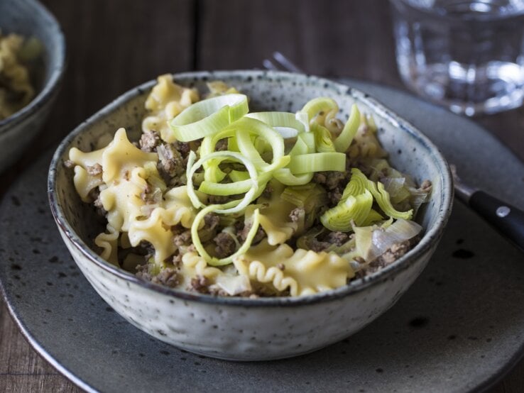 Draufsicht, schräg: eine Schüssel mit einer Hackfleisch-Lauch-Pfanne mit Pasta.