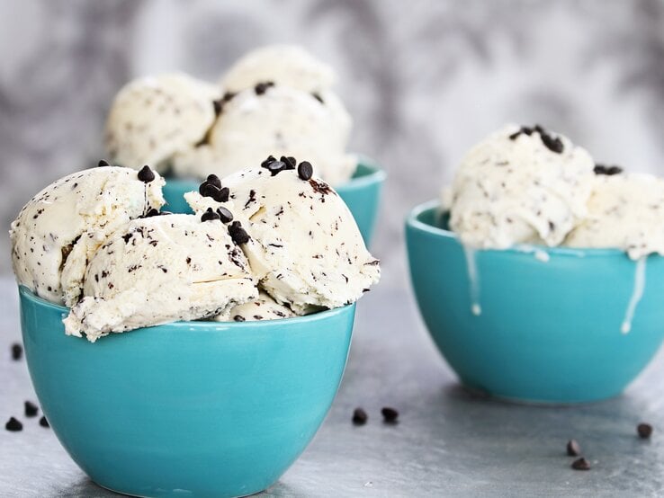 Hellblaue Schalen mit dem Straciatella-Eis auf hellem Holzuntergrund. | © istock/StephanieFrey