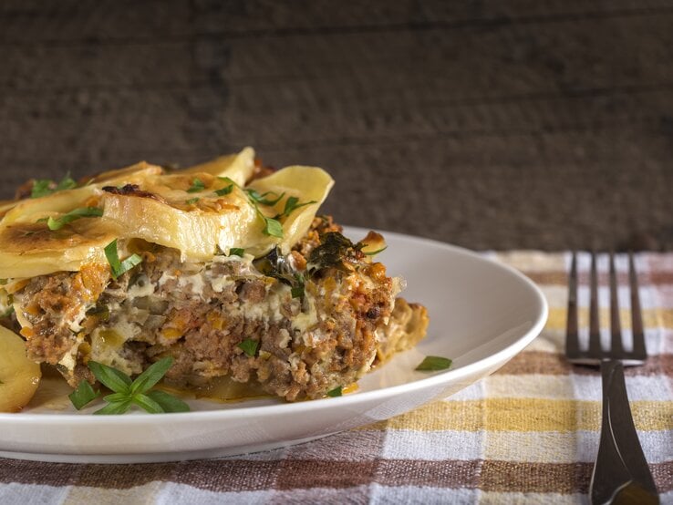 Ein Kürbis-Kartoffel-Auflauf mit Hackfleisch auf einem Teller / Bildausschnitt / Frontal
