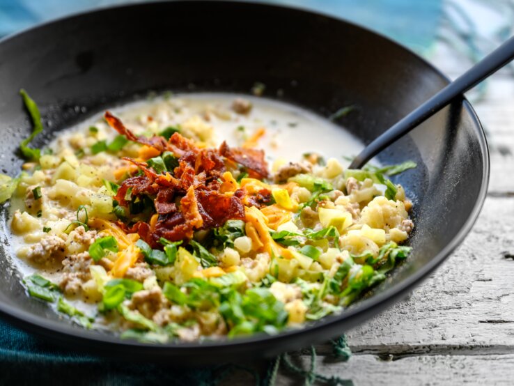 Hackfleisch, Bacon und Käse in Sahnesoße in einer Pfanne.