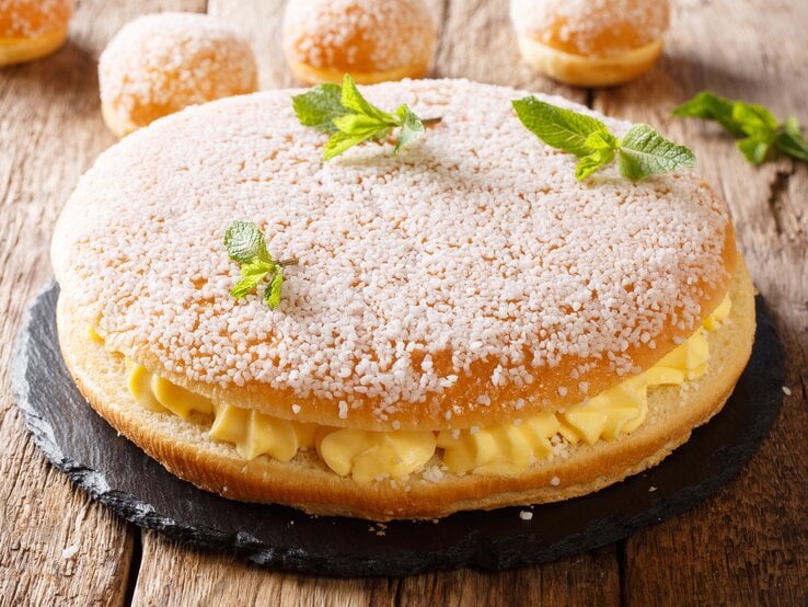 Kuchen mit Hagelzucker und Cremefüllung auf hölzernem Untergrund. 