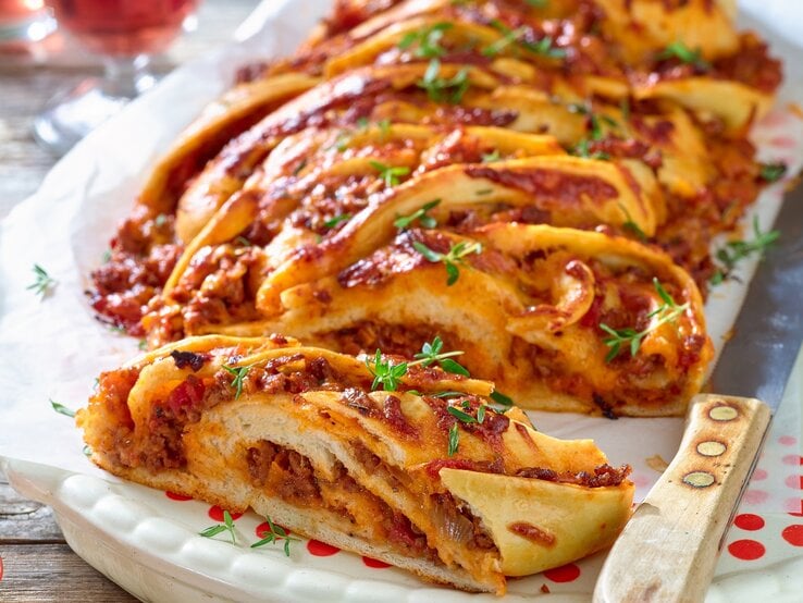 Der Bolognese-Hefe-Zopf auf einem hellen Tisch von schräg oben fotografiert.