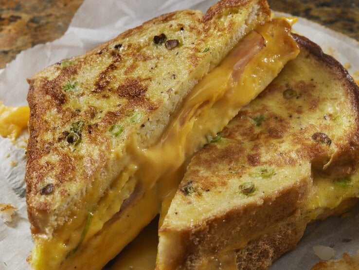 Das Arme-Ritter-Sandwich auf Küchenapier und einem Marmortisch.