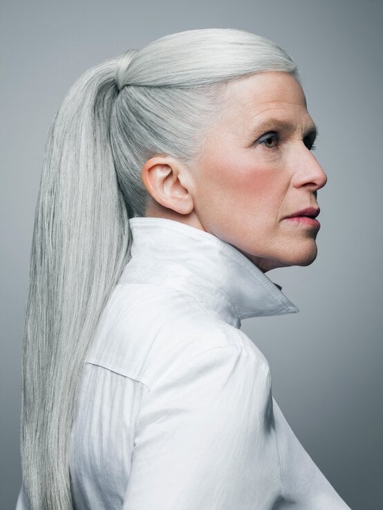 Frau mit grauen Haaren trägt einen streng gebundenen Pferdeschwanz, der mit einer Haarsträhne umwickelt ist. | © Andreas Kuehn/Getty Images