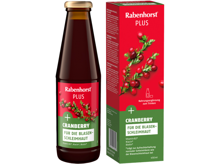 Rabenhorst-Cranberrysaft Cranberry Plus in brauner Flasche vor farblich passender Verpackung mit Abbildung von frischen Cranberries und grünen Zweigen. | © Rabenhorst