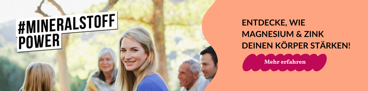 Frau um die 40 sitzt auf Picknickdecke umgeben von anderen Personen | © iStock/Paul Bradbury