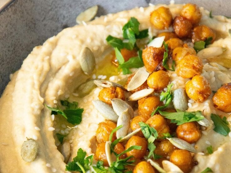 Cremiger Hummus mit gerösteten Kichererbsen, Petersilie und Kernen. | © Pexels/ Dilara via Canva.com