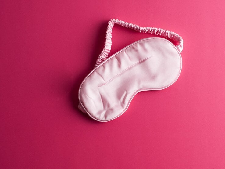 Schlafmaske auf rosa Untergrund.