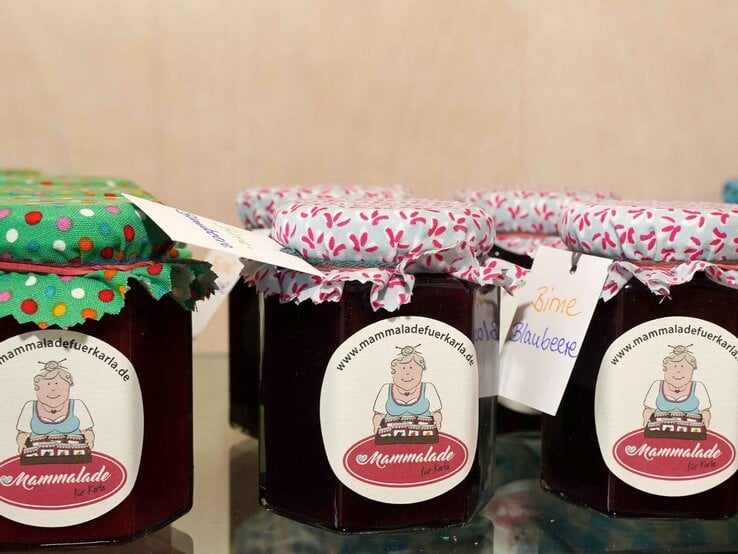 Sechs Gläser mit hausgemachter Marmelade, liebevoll verpackt mit bunten Stoffdeckeln und Etiketten mit Handschrift. | © GOLDENE BILD der FRAU