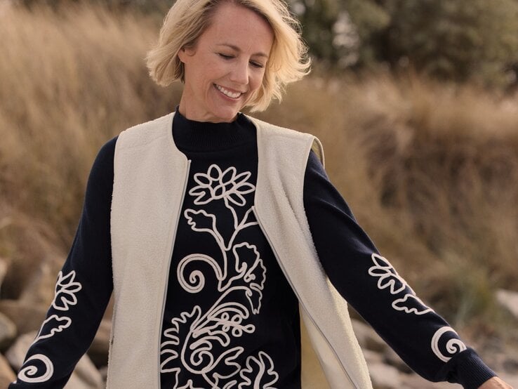 Zu sehen ist eine blonde Frau mit Bob mittleren Alters, die einen Pullover von Bonita trägt.