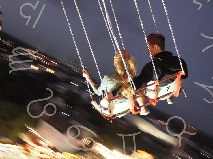 Ein Paar sitzt nebeneinander auf Schaukelsitzen eines Karussells in der Nacht. Die Frau hat lange, blonde Haare und trägt eine Jeansjacke, während der Mann dunkle Kleidung trägt. Im Hintergrund sind verschwommene Lichter einer Stadt oder eines Jahrmarkts zu sehen. Rund um das Bild sind verschiedene astrologische Symbole zu sehen: Zwillinge, Stier, Löwe, Krebs, Jungfrau und Waage.