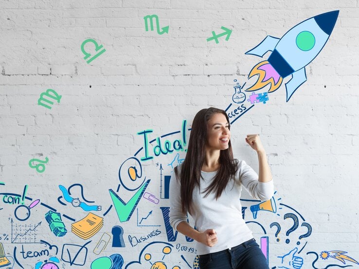 Eine junge Frau in einem weißen Pullover steht vor einer weißen Ziegelmauer und hebt triumphierend die Faust. Um sie herum sind verschiedene bunte Zeichnungen, die kreative Ideen, Erfolg und Geschäftssymbole wie eine Rakete, ein Häkchen, ein Wissenschaftssymbol und Geldscheine darstellen. Außerdem sind astrologische Symbole an der Wand zu sehen.