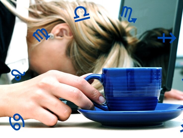 Das Bild zeigt eine erschöpfte Person, deren Kopf auf einem Tisch ruht, während sie eine blaue Tasse in der Hand hält. Im Hintergrund ist ein Laptop zu sehen, was darauf hindeutet, dass die Person möglicherweise überarbeitet ist oder eine Pause einlegt. Um die Person herum schweben verschiedene Sternzeichensymbole, was darauf hindeutet, dass der Artikel wahrscheinlich das Thema Astrologie behandelt und möglicherweise die Auswirkungen der Sternzeichen auf das Wohlbefinden oder die Stressbewältigung im Fokus hat.